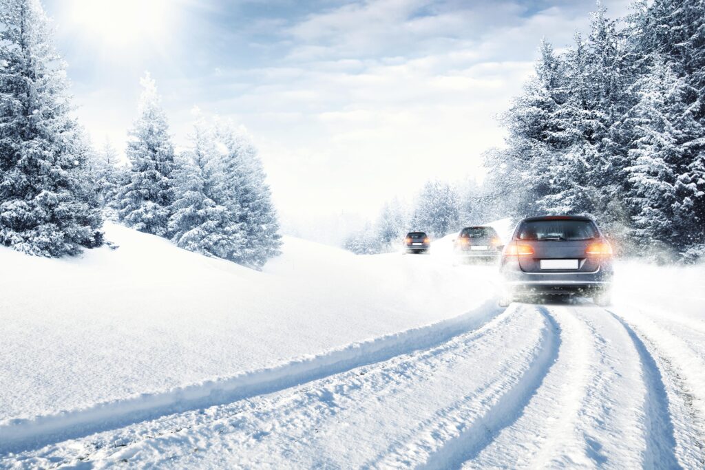 Car driving on a snowy, icy road in winter