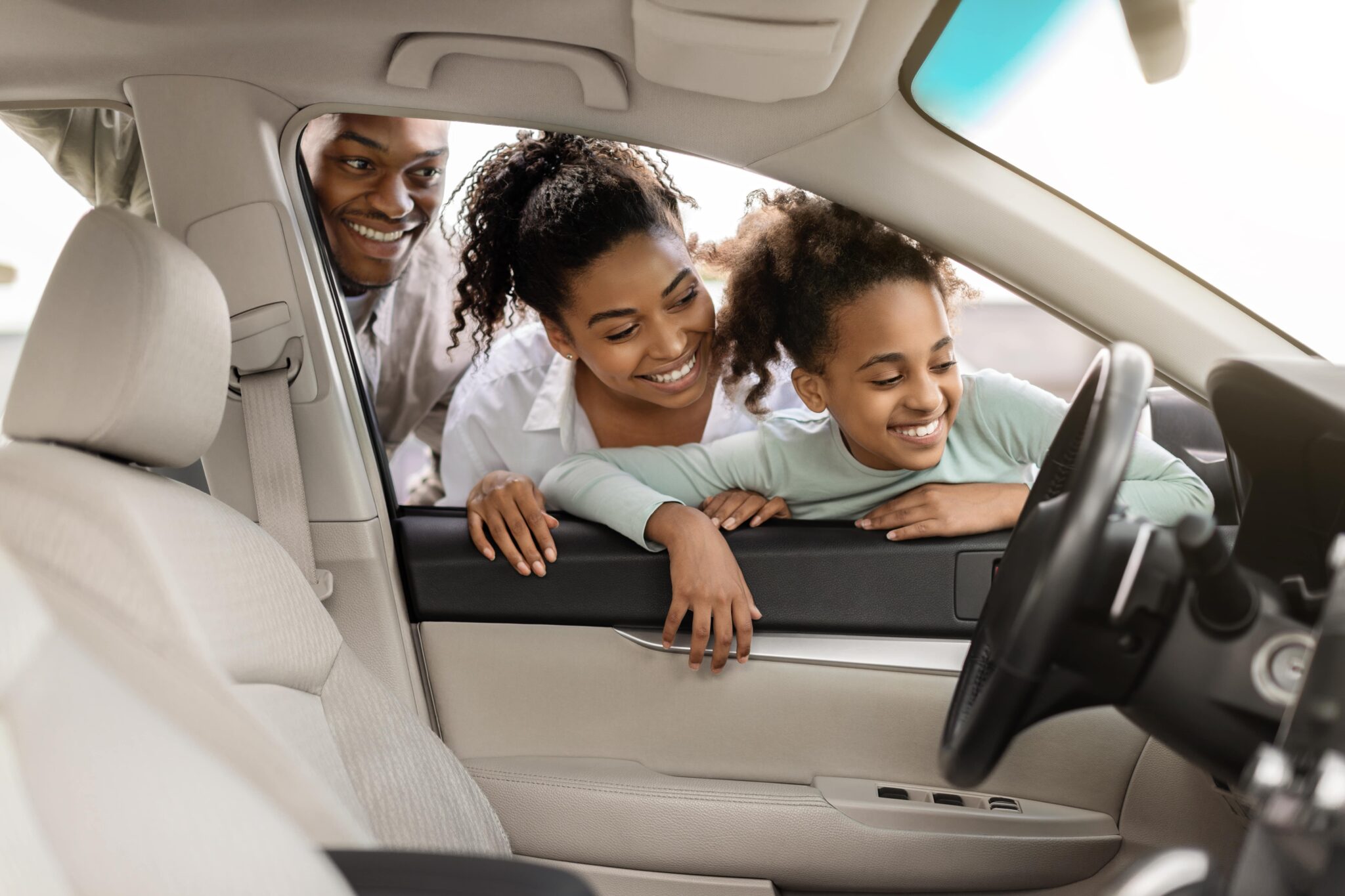 A family buying a used car on Carvana and looking through the window at the car's interior