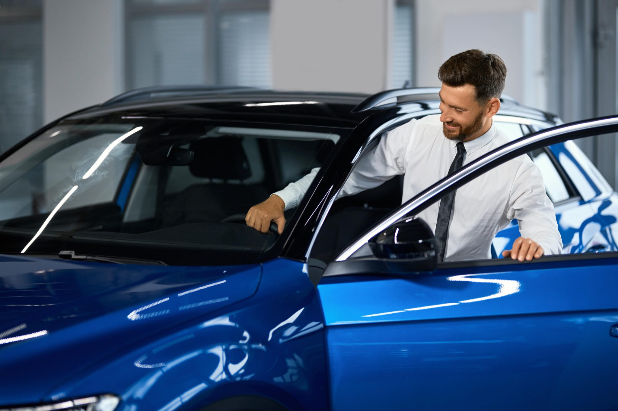 A man enters a luxury car to inspect the interior