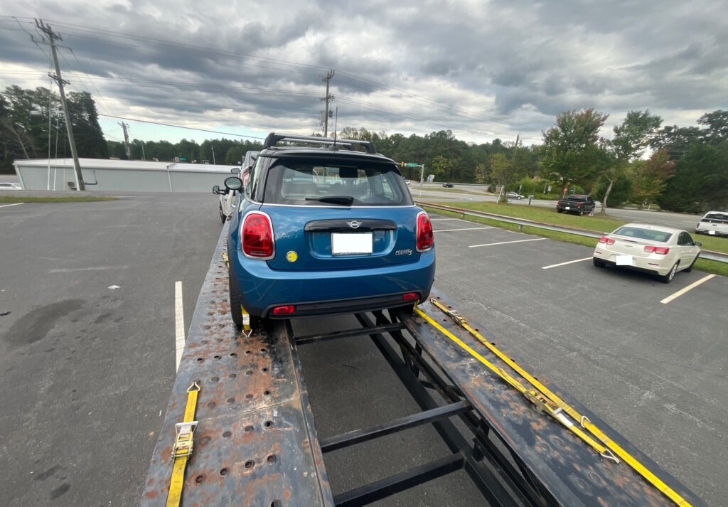 Blue mini cooper on hauler with open transport